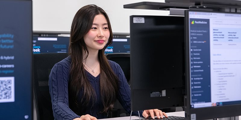 Student sat at desk using computer in computer room
