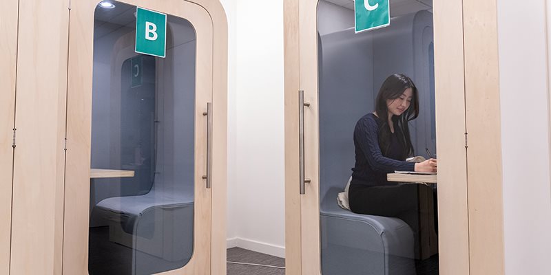 Student sat inside library study pod