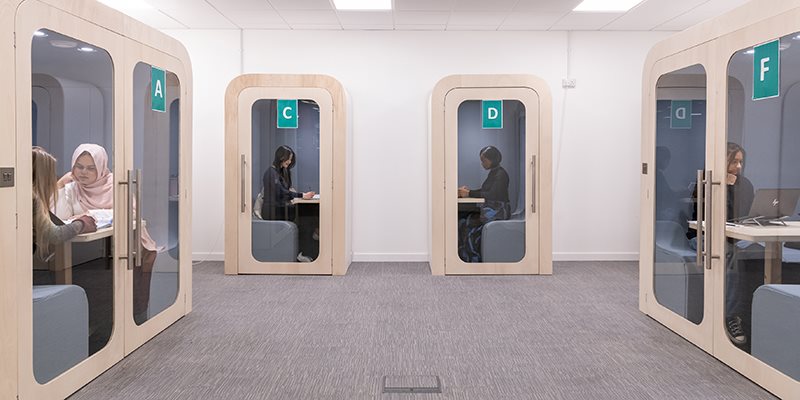 Study pods in library with students sat inside
