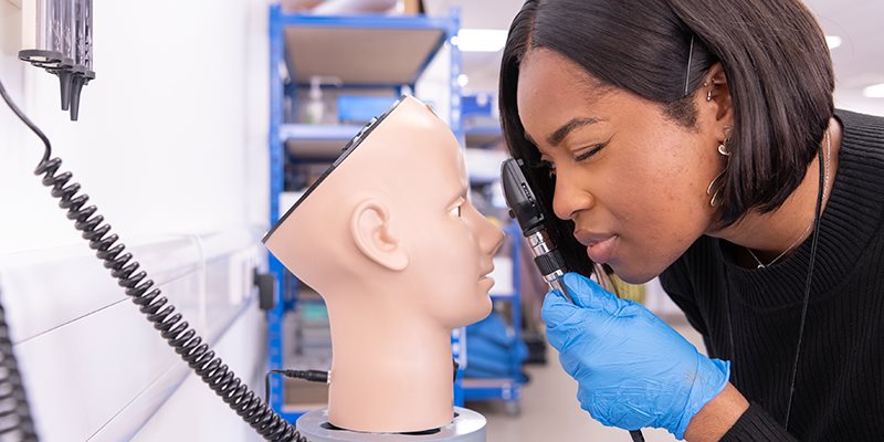 Student examining mannequin in clinical skills practice space