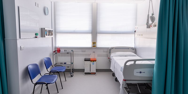 Hospital bed in bay with privacy curtain in simulation hospital setting