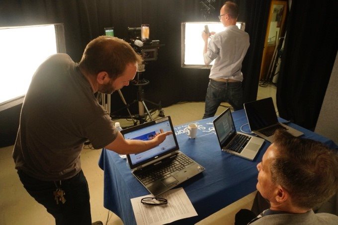 A technician points out information on a laptop in the studio.