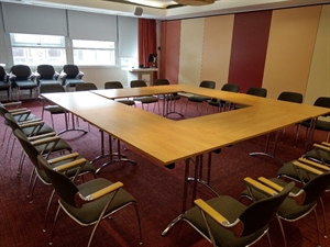 Tables and chairs laid out in boardroom style.