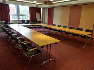 Tables and chairs laid out in horseshoe style.