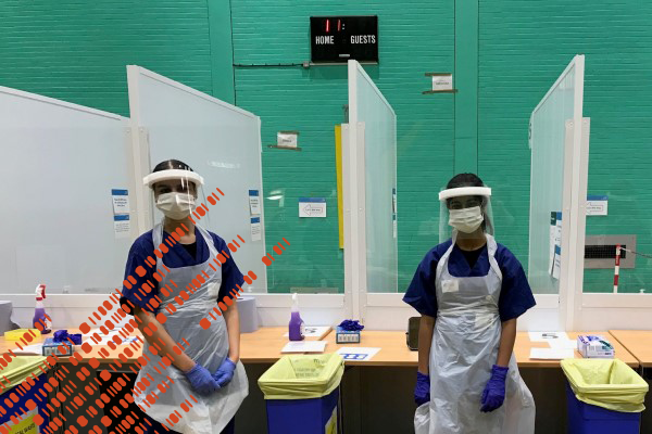 Two students stood in Covid-19 centre wearing full PPE