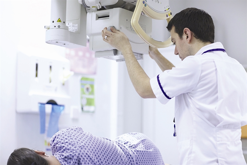 A radiographer scanning a patient.