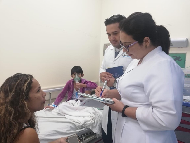 Doctos working with the parent of a child with asthma.