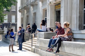 Students chatting on a building's steps.