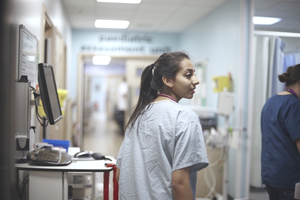 An student doctor walking a hospital corridor.